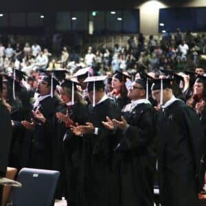 a group of graduates worshipping