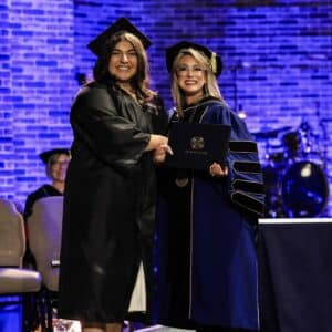 president angie giving a diploma to a female student