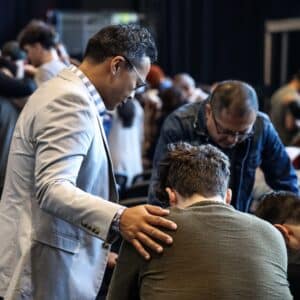 dr. ken bringas praying over a group of men