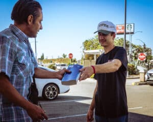 collin handing a man a bible on the street