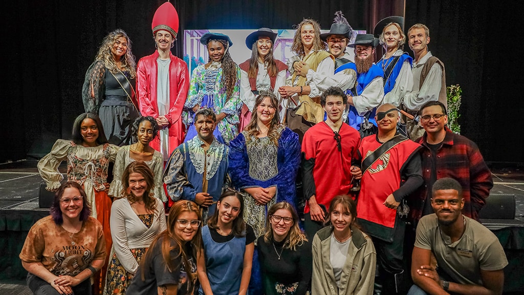 the entire cast photo smiling at the front of stage