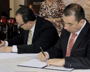 dr aldana signing an agreement with pastor ricardo