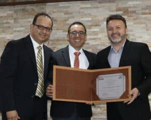 dr aldana smiling with pastor ricardo and his pastoral team while holding a certificate