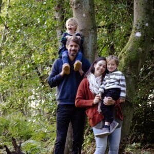 chris and his family smiling in the woods