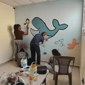 lpu students painting a whale in a classroom