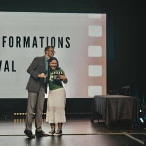 a female student hugging Andy as she receives her award