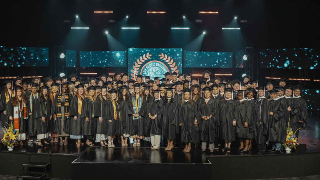 a group photo of all the graduates in their caps and gowns on stage