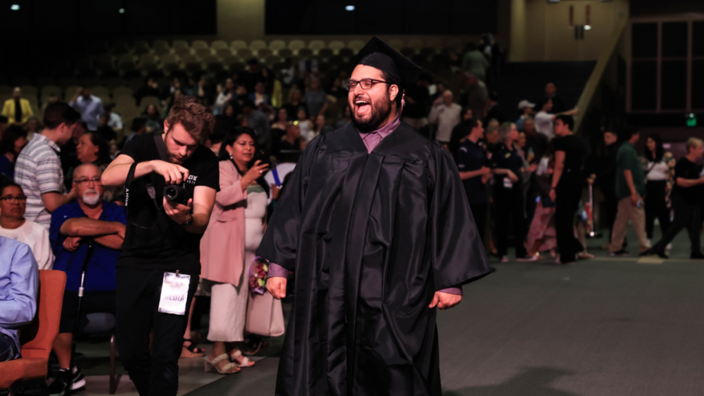 efren while smiling and walking down the aisle during graduation