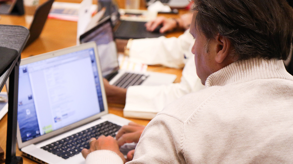 Adult learner working on a laptop during a professional learning session