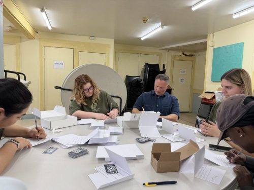 Filling out invitation cards to Anchor Church, where Noah and Rachele Coombs pastor