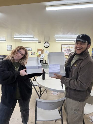 Filling out invitation cards to Anchor Church, where Noah and Rachele Coombs pastor